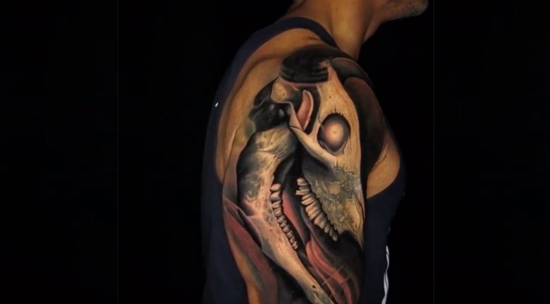 A close view of Dwayne Johnson’s right shoulder showing the completed forward-horned bull-skull tattoo