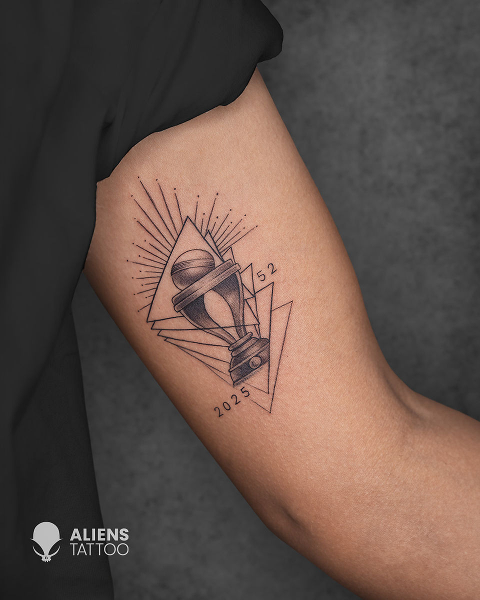 Geometric trophy tattoo with 2025 and 52 on Harmanpreet Kaur's inner upper arm