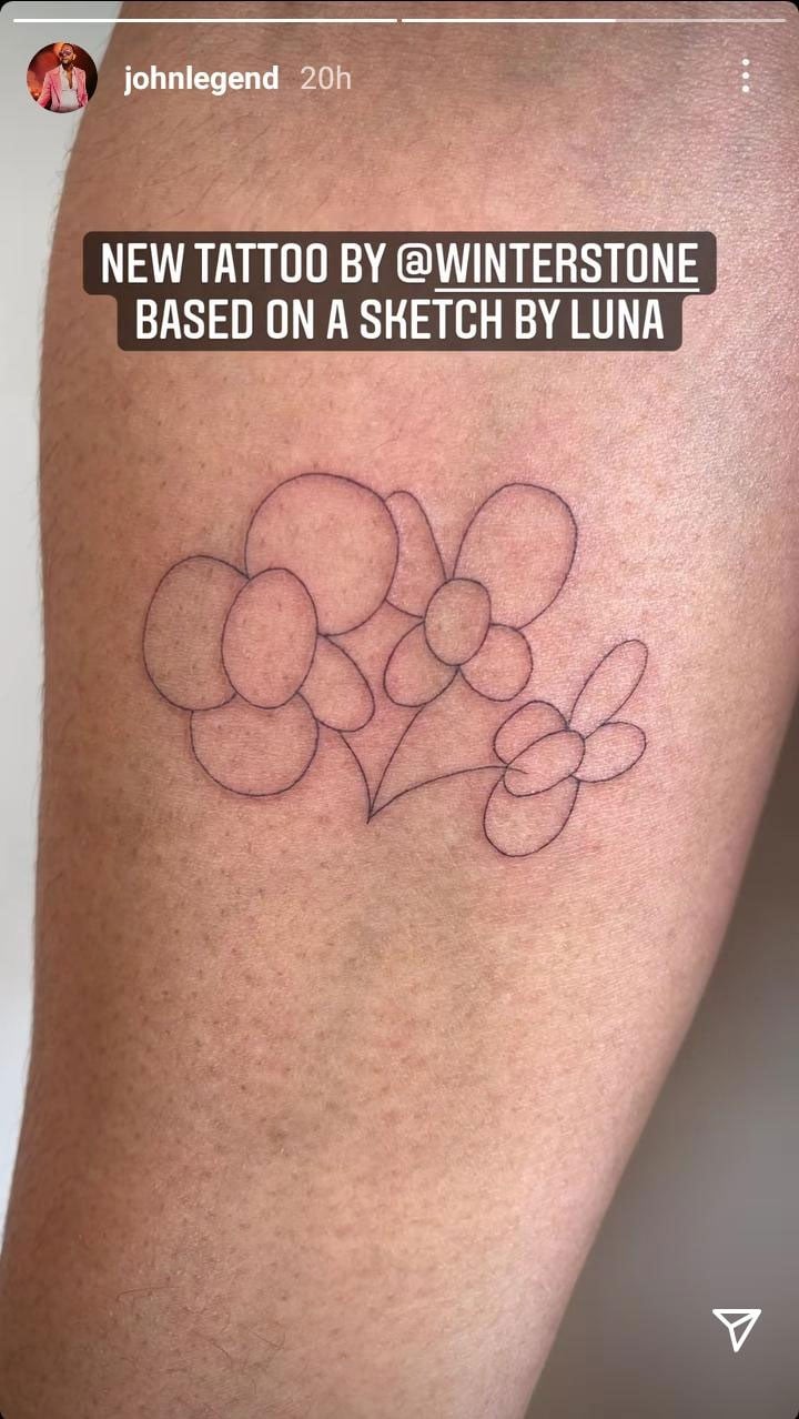 John Legend's completed three-flower outline tattoo on his right inner forearm