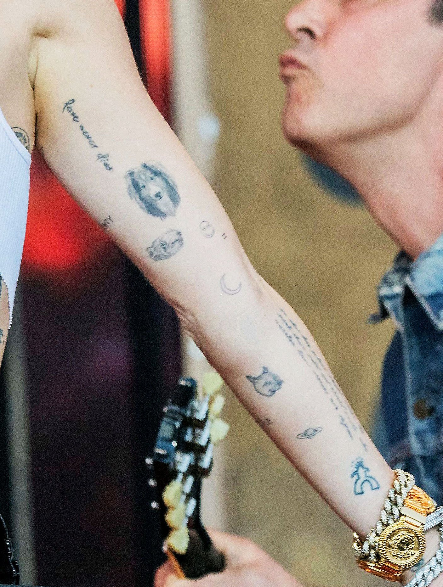 Source view of Miley Cyrus’s left arm showing the small ringed-planet tattoo near her wrist