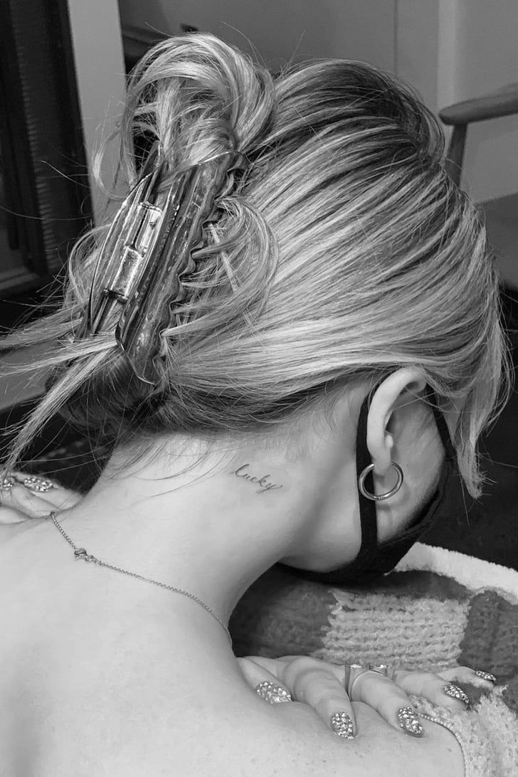 Black-and-white photo of Sabrina Carpenter with her hair pinned up, showing the small lucky script on her right nape
