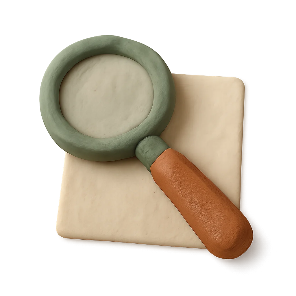 A clay magnifying glass lying on a blank sheet of paper.