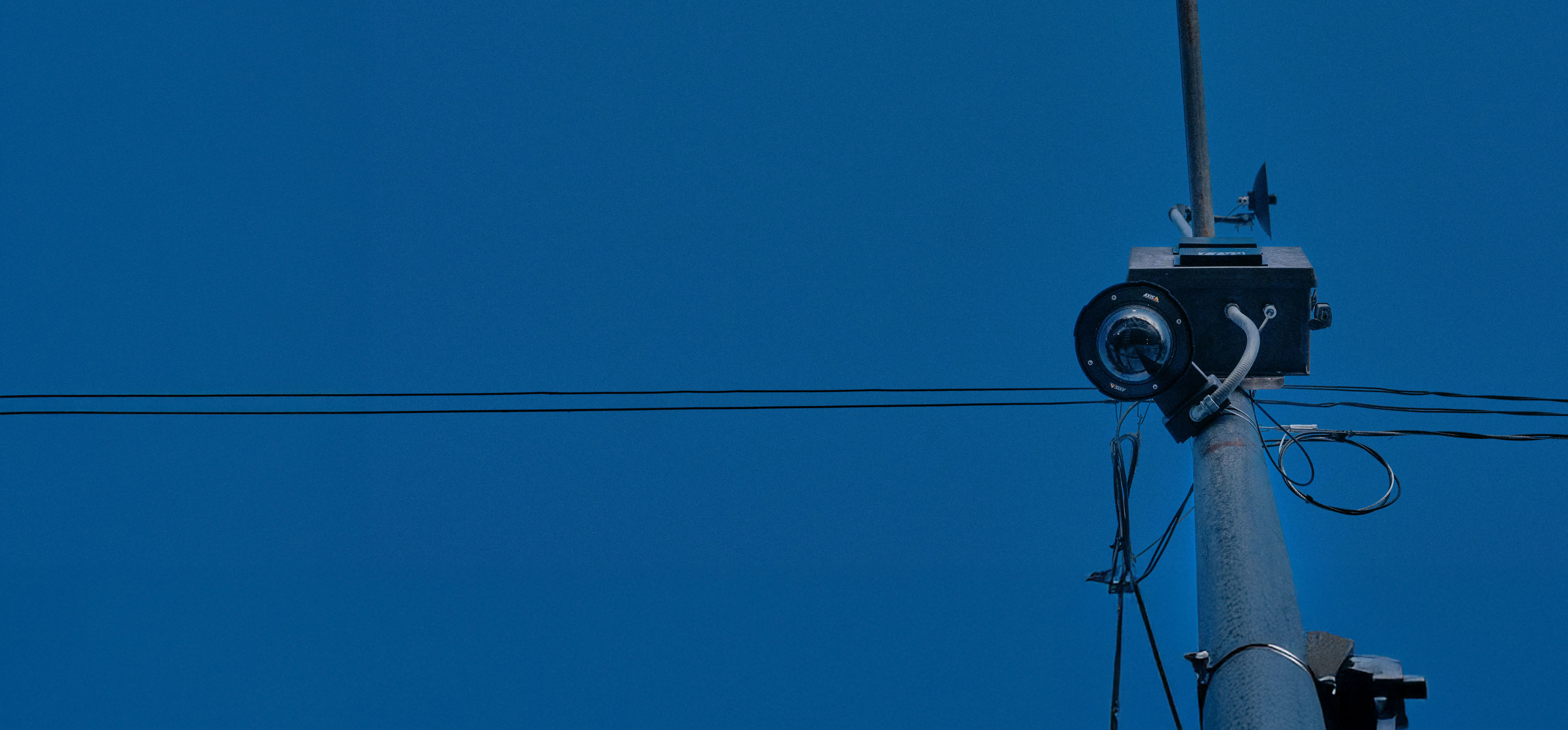 Cámara de vigilancia en un poste contra un cielo azul oscuro