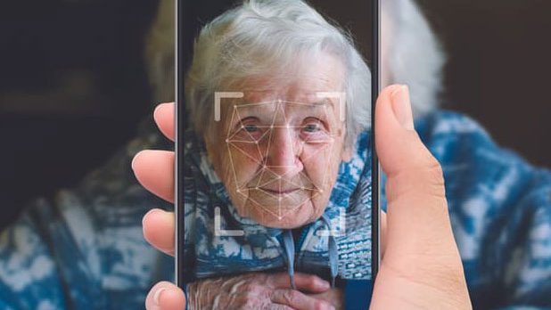 una persona sujetando un teléfono frente a una persona mayor, cuyo rostro es visible en la pantalla