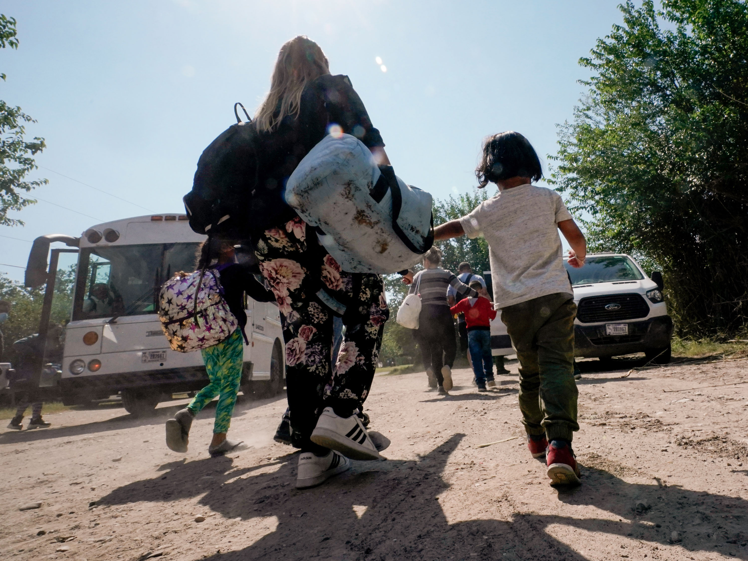 En esta foto de archivo del 16 de junio de 2021, una familia migrante de Venezuela se dirige a un vehículo de transporte de la Patrulla Fronteriza después de que ellos y otros migrantes cruzaran la frontera entre Estados Unidos y México y se entregaran en Del Rio, Texas.