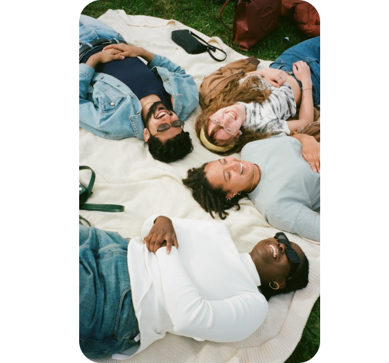 Four friends laying on the ground laughing