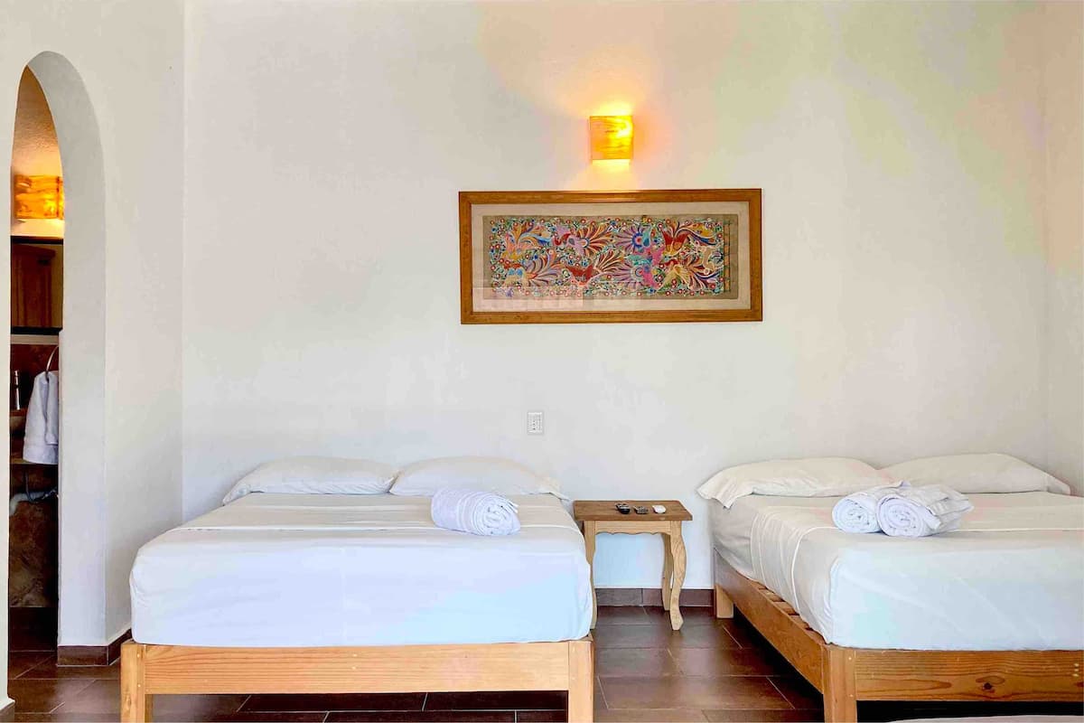 Habitaci&oacute;n 1 con capacidad para 5 personas. Cuenta con 2 camas matrimoniales y 1 sof&aacute; cama individual. Con ba&ntilde;o completo, aire acondicionado, ventilador de techo y smart TV con conexi&oacute;n a internet.