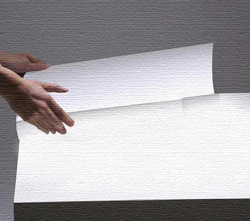 Someone inspecting paper on a light box