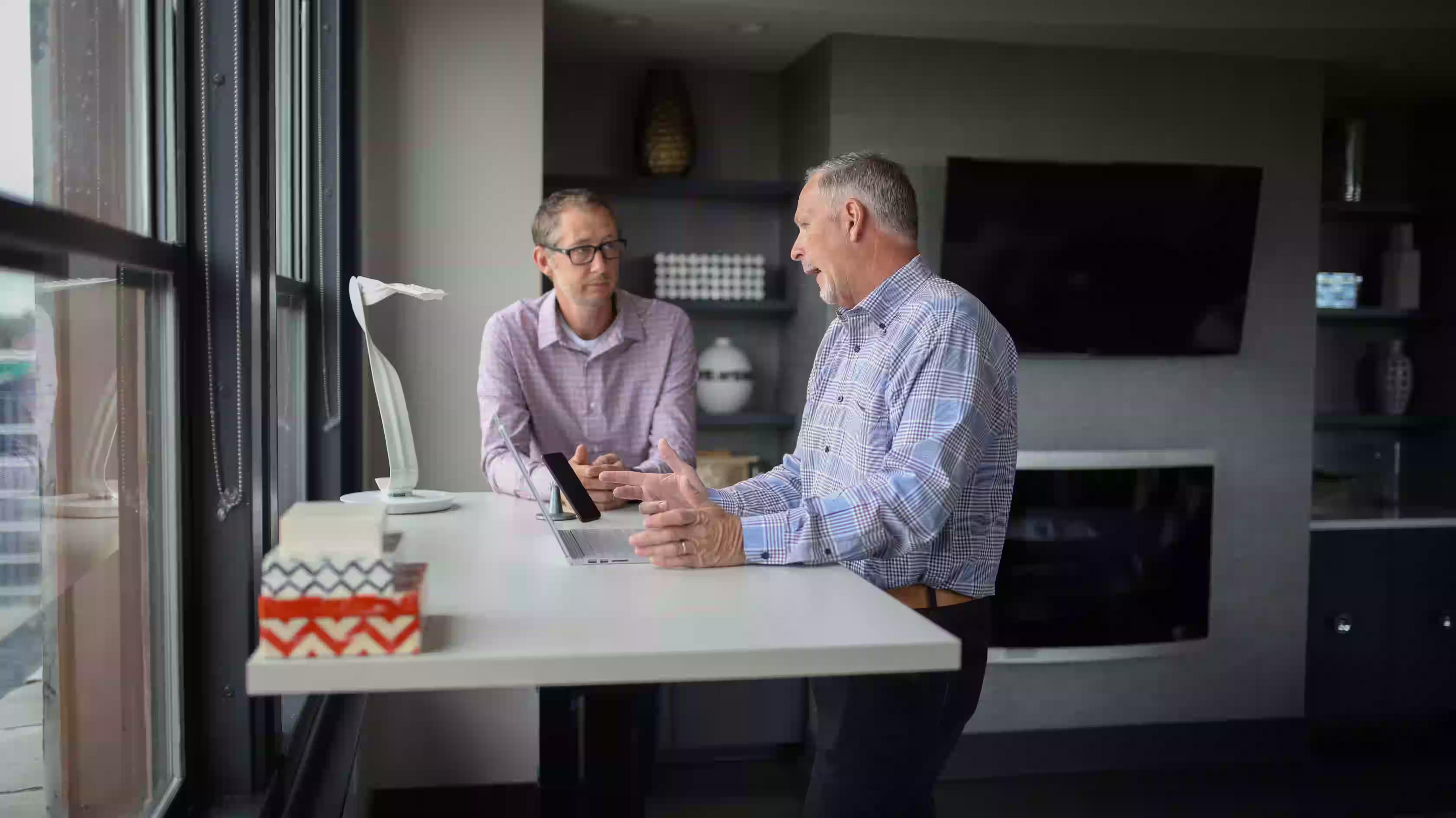 Construction company owner reviewing job cost reports with company accountant