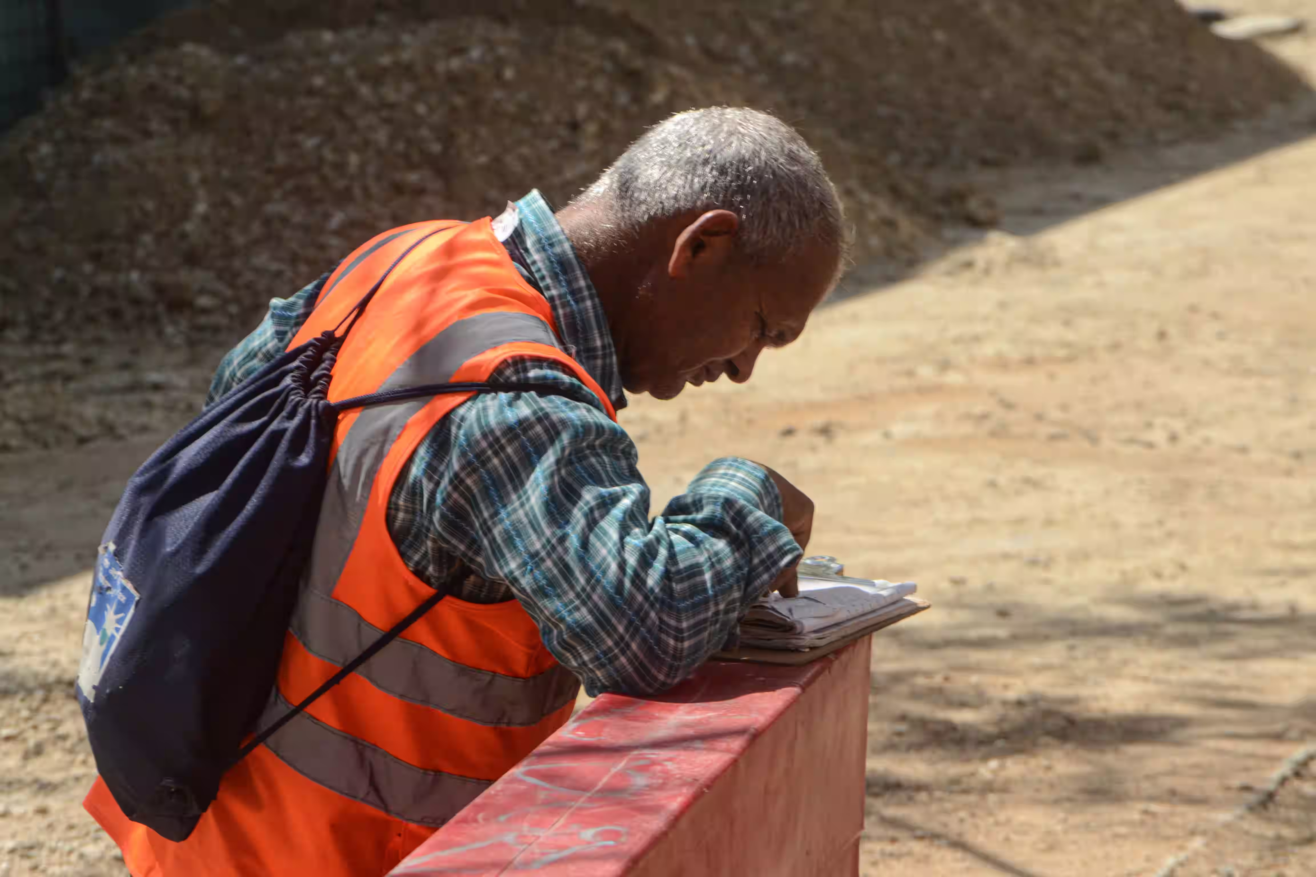 General contractor reviewing job cost reports on an active construction site