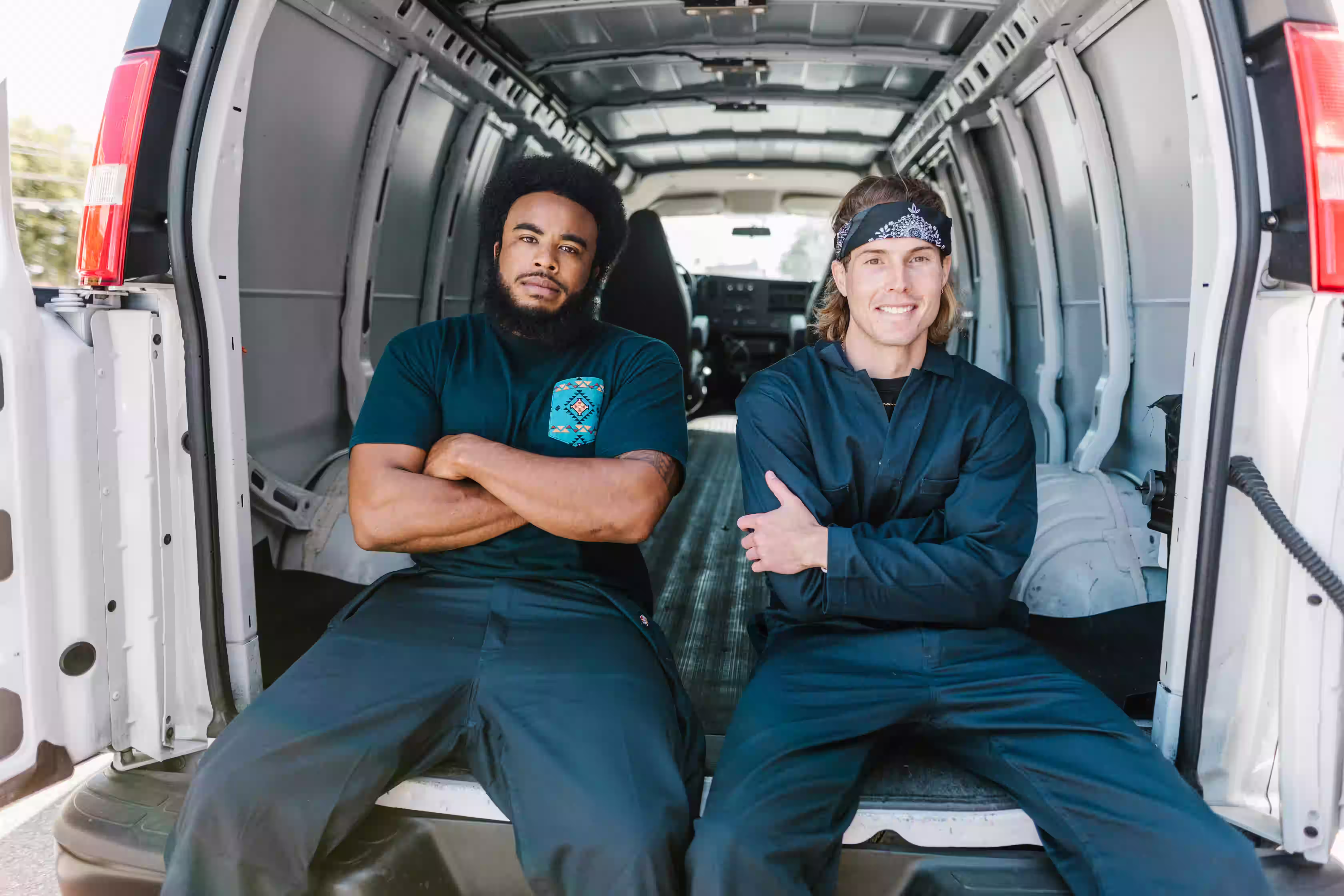 Two service tradesmen sitting in their service van