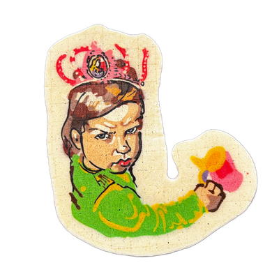 Pancake art depicting an original character called Grumpy Granddaughter: a young girl with brown hair in a braid, wearing a green long-sleeved shirt, a pink and red crown on her head, and holding a small pink and yellow object in her raised fist while wearing a scowling facial expression. Dan rende…
