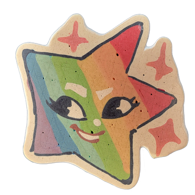 Pancake art depicting Charli, a JoP original character designed as an animated star shape with a cartoon cat face, featuring two pointed ear-like protrusions at the top, a smiling mouth, stylized eyes with lashes, a small round nose, and four four-pointed star accents on the border of the shape. Th…