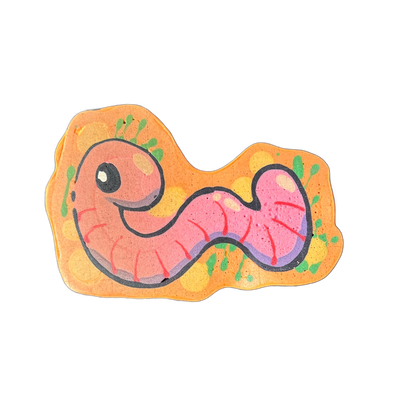 Pancake art of Hermie, a worm character from the JoP cast, depicted with a round head, a single round eye, small antennae-like protrusions, and a segmented body that curves in an S-shape across the composition. Drawn by Wella with bold black outlines and filled in orange, pink, and purple batter, s…