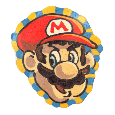 A cartoon face with a large round nose, a thick brown mustache, wide teal-irised eyes, and a red cap bearing a white circle with a red letter M, surrounded by a scalloped border alternating blue and yellow segments. Bold black outlines define the features, filled with areas of red, cream, brown, an…