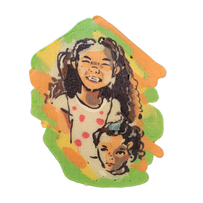 Pancake art depicting two children: an older child with long curly hair, eyes partially closed mid-laugh, wearing a light-colored top with red polka dots, positioned above a younger child with shorter curly hair and a more neutral expression, both rendered from approximately the chest up. Dan illus…