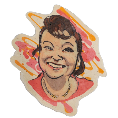 Pancake art portrait of a smiling woman with dark brown hair styled up and back, wearing a necklace and a red or pink top, shown from the shoulders up against a background of pink and orange batter splashes. The portrait uses bold dark outlines with filled areas of peach and tan for skin tones, dee…