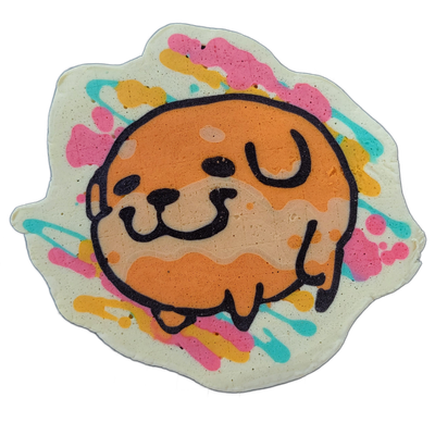 Pancake art of Poffridge, a JoP original character depicted as a round, Shiba Inu-shaped poffertje with an orange and tan face, small dark nose, curved mouth, U-shaped eyes, and stubby legs tucked beneath the body. Bold black outlines define the figure against a white background splattered with irr…