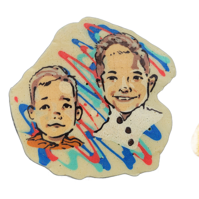 Pancake art depicting two children, Hayes and Reid, shown from the shoulders up side by side: the child on the left appears younger with a round face, short hair, and a neutral expression, wearing what looks like an orange-collared shirt; the child on the right appears older with slightly longer ha…