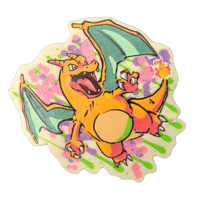 A pancake art depiction of Charizard, the orange fire-breathing dragon-type Pokémon from the Pokémon franchise, shown in a dynamic forward-facing pose with wings spread wide, mouth open revealing teeth and a red interior, clawed feet forward, and a curled tail with an orange and yellow flame tip. T…