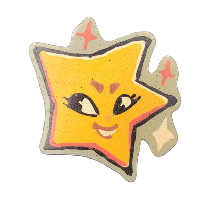 Pancake art depicting Charli, a JoP original character designed as a living star from Vincent Van Gogh's The Starry Night, rendered as a tilted five-pointed star shape with a cartoon face featuring heavy black-outlined eyes with white highlights, rosy cheek marks, a small nose, and a smiling mouth…