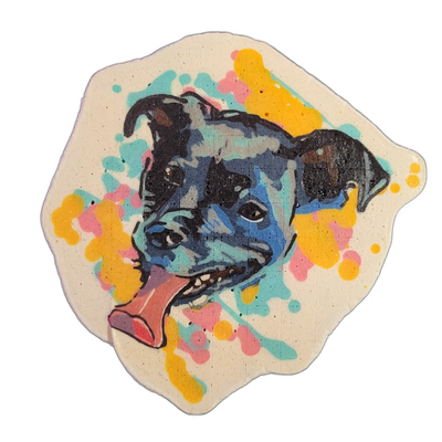 Pancake art portrait of a dog named Harpo, depicted from the neck up facing slightly left with mouth open and tongue extended downward to the left, ears folded back, and a white blaze visible on the face against a dark muzzle and head. Rendered with bold black outlines and broad color fills in blue…