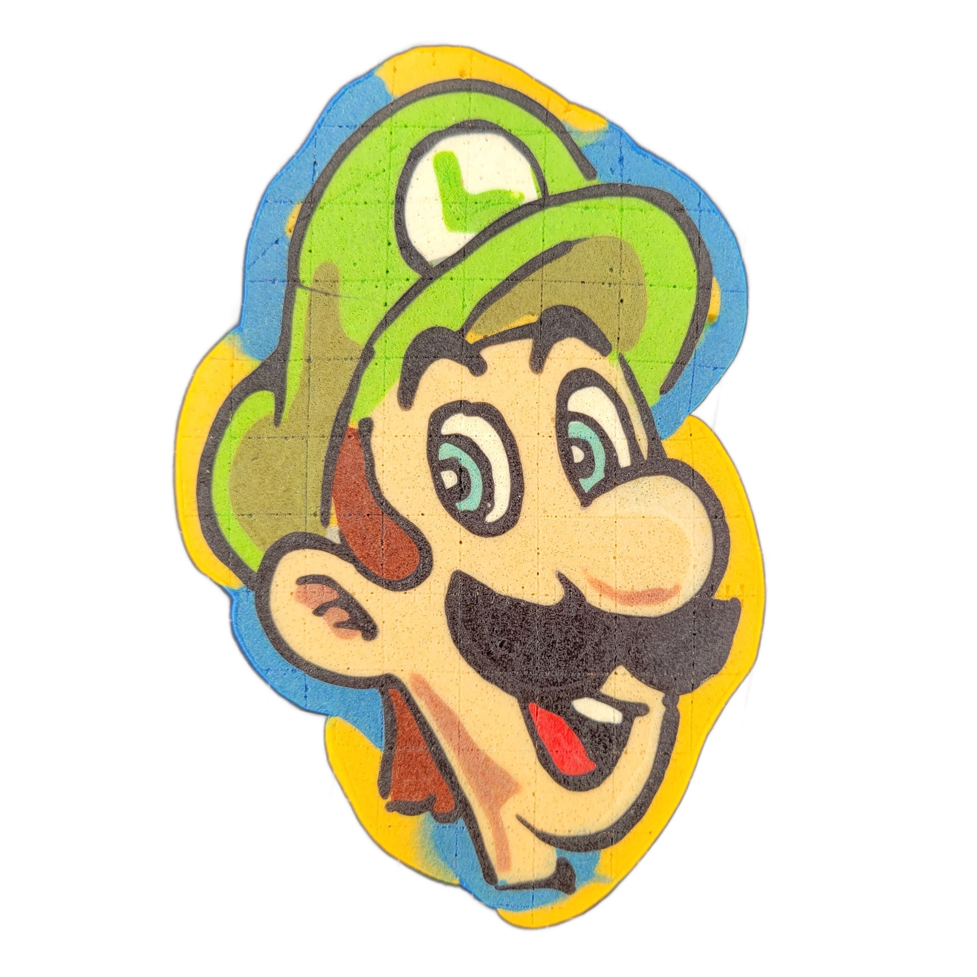 A cartoon face with a green cap marked with the letter 'L,' a large black mustache, blue eyes, a prominent round nose, an open mouth with a red tongue, and sideburn-like brown ear details, surrounded by a layered border of yellow and blue batter. The pancake art uses bold black outlines with areas…