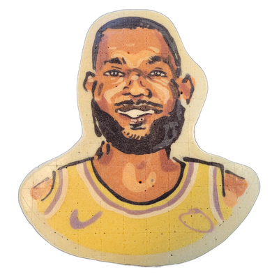 Pancake art portrait of LeBron James, depicted from the chest up, wearing a yellow and purple Nike basketball jersey with a Nike logo and the number 23 visible on the chest, smiling with a dark beard and close-cropped hair. Rendered by Dan with bold dark outlines, warm brown and orange skin tones,…