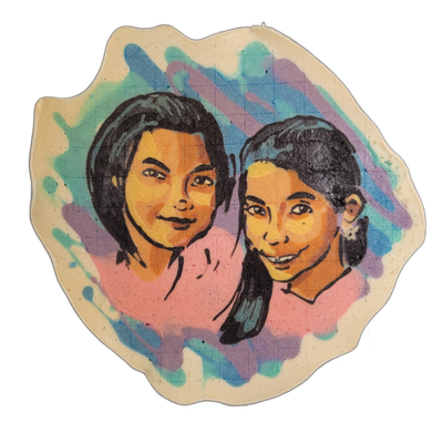 Pancake art portrait of two young people with dark hair posed close together, both facing forward with slight smiles; the person on the left has shoulder-length straight hair and the person on the right has hair pulled back and wears small flower-shaped earrings and braces.