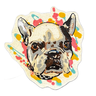 A pancake art portrait of a dog named Edgar, depicting the head and face of a French Bulldog with bat-like erect ears, a broad flat muzzle, deep-set brown eyes with white highlight dots, and a slightly open mouth showing teeth, surrounded by splashes and drips of pink, yellow, and teal batter again…