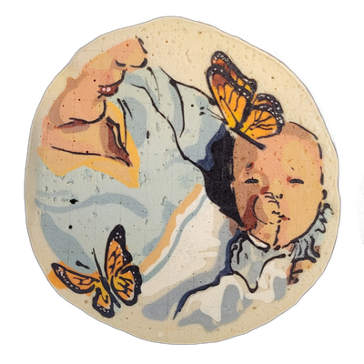 Pancake art depicting an adult figure facing left with eyes closed and lips slightly parted, holding or cradling a bald infant whose face is turned forward; two monarch butterflies are present, one near the lower left and one resting on the infant's head. Rendered with bold black outlines and flat…