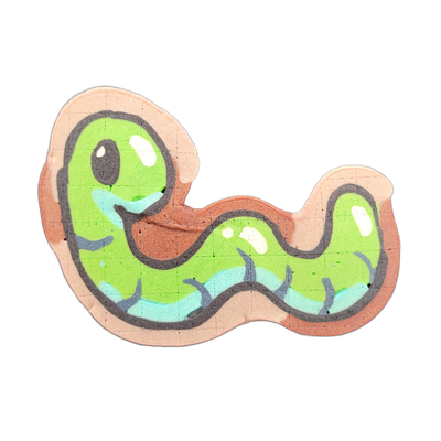 Pancake art of Hermie, a cartoon worm character from the JoP cast, depicted in a loose S-curve body with a rounded head facing left, one visible dark eye with a white highlight, a small open mouth, and leg-like appendages along the underside rendered in blue-gray tones against the green body. The p…