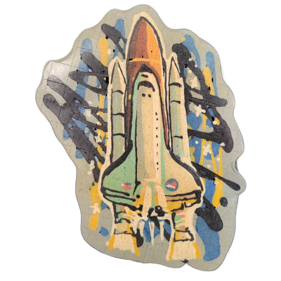 Pancake art depicting a space shuttle mounted on its external tank and two solid rocket boosters, viewed from a front-facing, slightly elevated angle as if the vehicle is launching upward toward the viewer. Bold black outlines define the shuttle, tank, and boosters, with fill areas in cream, tan, g…