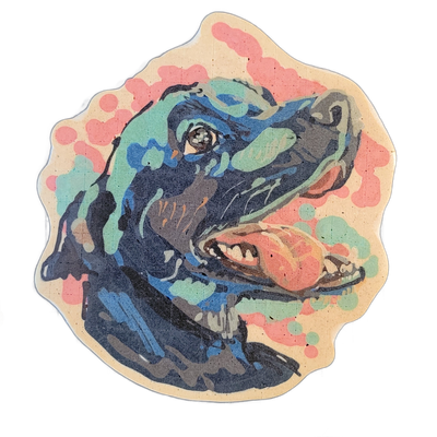 A pancake art portrait of a dog named Coco, depicted from roughly the chest up with head tilted back and mouth open, tongue visible, showing teeth and the inside of the mouth in coral and peach tones against a dark navy and teal-rendered face and body. The piece uses bold outlines with layered colo…