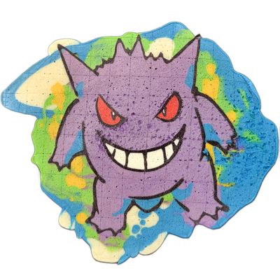 A pancake art piece depicting Gengar, a purple cartoon creature with a wide toothy grin, red eyes, pointed ears, and small clawed hands and feet, set against a background of splashed blue, green, yellow, and white batter. Bold black outlines define the figure and facial features, with solid purple…