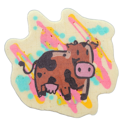 A cartoon-style cow rendered in brown with black outlines, facing right, with a pink muzzle, dark spots, a small tail, and an udder visible beneath the body. The figure is drawn with bold black outlines and filled with brown batter, set against a cream background decorated with diagonal streaks in…