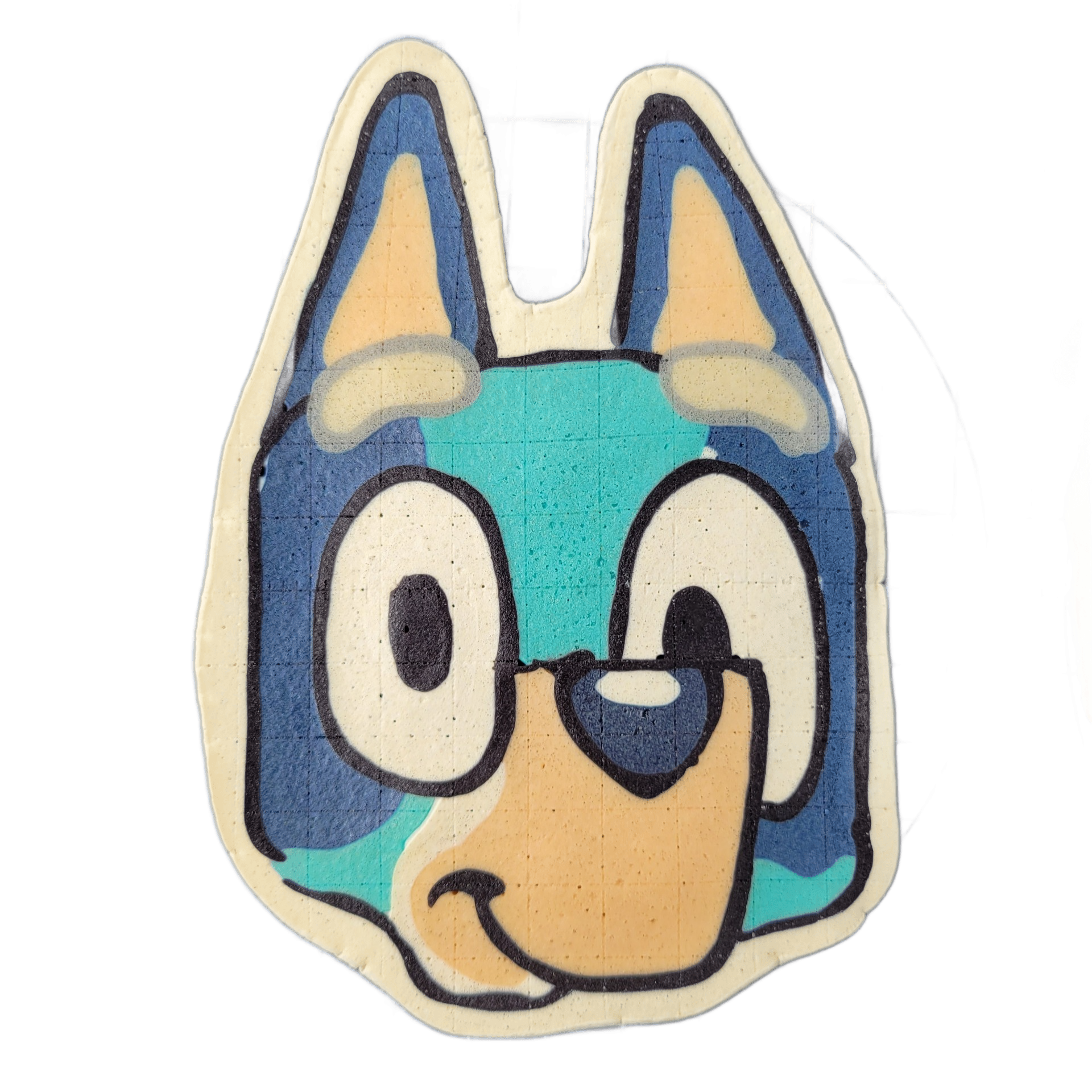 Pancake art depicting the head of Bluey, a cartoon blue heeler puppy character, facing forward with two pointed ears, large round white eyes with dark pupils, one eye appearing half-closed, a tan muzzle, and a small dark nose. Rendered by Dan using bold dark outlines and flat color fills in shades…