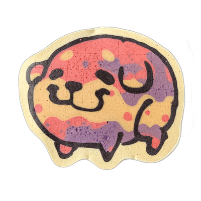 Pancake art depicting Poffridge, a Shiba Inu–shaped sentient poffertje from the JoP character cast, shown in a rounded, low-slung body form with small legs, a broad muzzle with a simple nose, and arched brow lines rendered in bold dark outlines on a cream-colored base. The interior is filled with o…