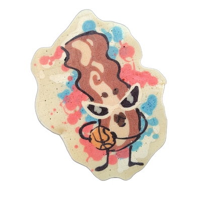 Pancake art depicting Sugar, a JoP original character designed as a strip of bacon, wearing white cateye sunglasses and holding a basketball with thin stick-like arms and legs against a background of pink and blue batter splatters. Bold dark outlines define the figure, with brown and tan fill tones…