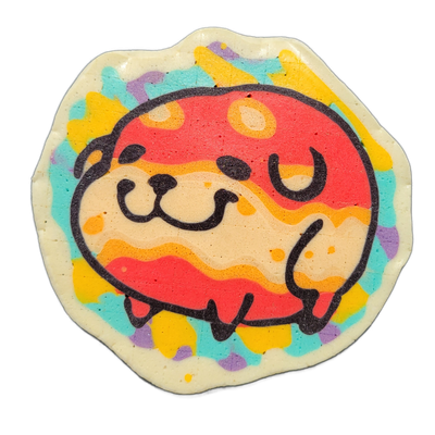 Pancake art depicting Poffridge, a Shiba Inu–shaped sentient poffertje from the JoP character cast, shown as a round face with small curved eyes, a dog-like muzzle with two dot nostrils, and a bold dark outline framing the whole head; the border area of the pancake features irregular patches of tea…