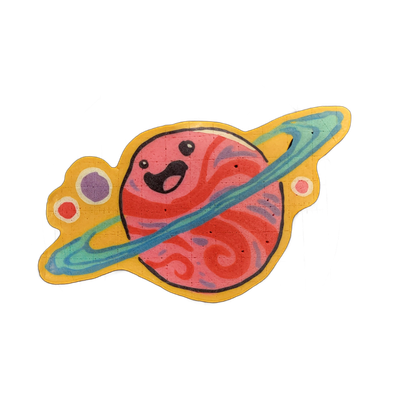 Saturnina, a JoP original character depicted as a round planet with a cartoon face — wide-open mouth, small dot eyes, one winking — encircled by a diagonal ring system, with small orbiting circles on either side of the ring ends. Drawn by Dan in pancake art with bold black outlines, a pink and red…
