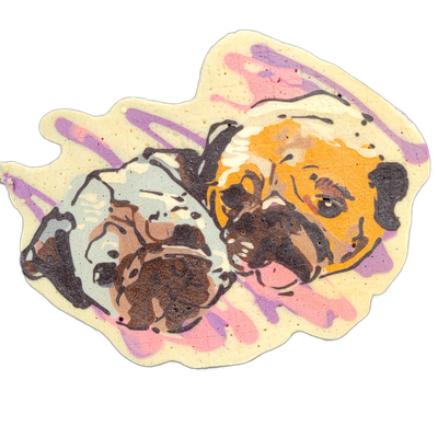 Pancake art depicting two dogs shown from the neck up, side by side, both facing the viewer at a slight angle; the dog on the left has a gray-and-brown coat with a broad, flat muzzle and wrinkled face, and the dog on the right has an orange-toned coat with similar wrinkled, brachycephalic features…