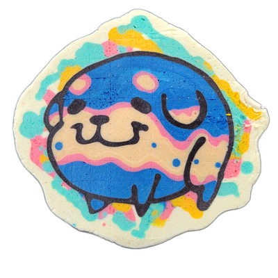 Pancake art depicting Poffridge, a Shiba Inu–shaped sentient poffertje from the JoP cast, shown as a round, squat face with closed eyes, a small snout with dot nostrils, and stubby limbs visible at the lower right, set inside a circular border against a white scalloped outer edge with scattered pat…
