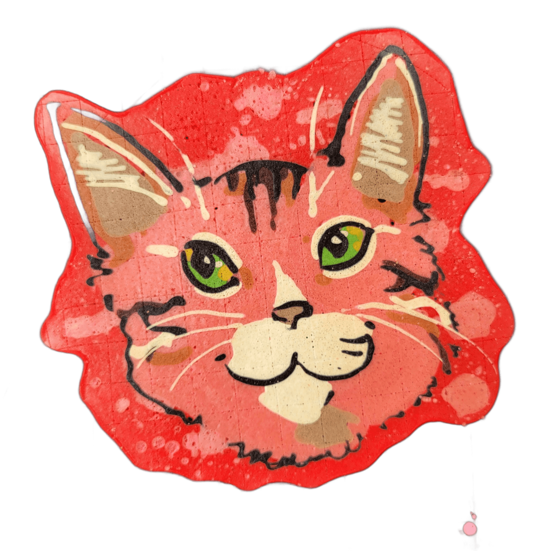 A pancake art piece depicting a cat's face with green eyes, a white muzzle area, small triangular ears with inner detail, and tabby-style stripe markings rendered in dark brown and black lines across the forehead and cheeks.