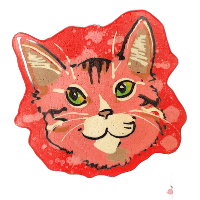 A pancake art piece depicting a cat's face with green eyes, a white muzzle area, small triangular ears with inner detail, and tabby-style stripe markings rendered in dark brown and black lines across the forehead and cheeks.