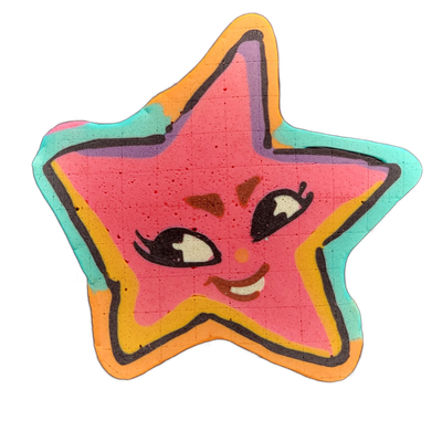Pancake art depicting Charli, a star-shaped original character from the JoP cast, rendered as a five-pointed star with a cartoon face featuring two wide eyes with lashes, rosy cheeks, and a small open smile. Bold black outlines define the star shape and facial features, with a hot-pink interior, a…