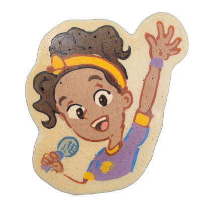 Pancake art depicting a cartoon character named Jack, rendered as a child with dark curly hair pulled up and held with a yellow hair accessory, wearing a violet and blue top with yellow accents, holding a microphone-like object in one hand while raising the other hand open with fingers spread, mout…