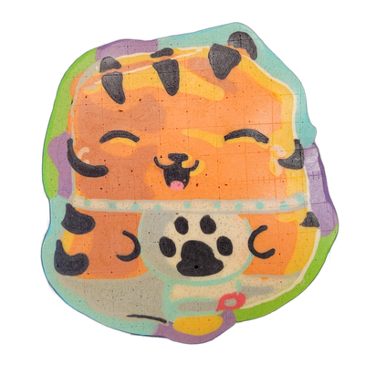 Pancake art of a cartoon tiger cat rendered as a round, squat figure with closed, curved eyes, a small open mouth with a pink tongue, striped orange fur with dark irregular markings on the head and sides, small rounded ears, and a lighter-colored belly area with a large black paw print in the cente…