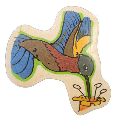A hummingbird in mid-flight with wings spread wide, its long beak inserted into a yellow and orange flower shown in the lower right; the body is rendered in reddish-brown and olive tones, the wings in blue and yellow-green, and the head in teal-gray, all set against a blue background with a green o…