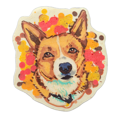 Pancake art portrait of a dog named Biscuit, shown from the shoulders up, facing forward with pointed ears, brown eyes, a dark nose, and white facial markings consistent with a Pembroke Welsh Corgi-type appearance, surrounded by a loose arrangement of circular and irregular splatter shapes in red,…
